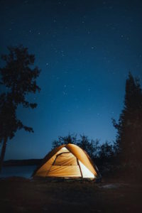 camping tent light up at night in the woods